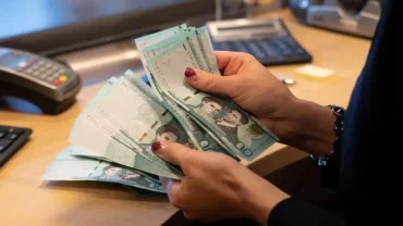 A Bank Teller Counting Dominican Pesos