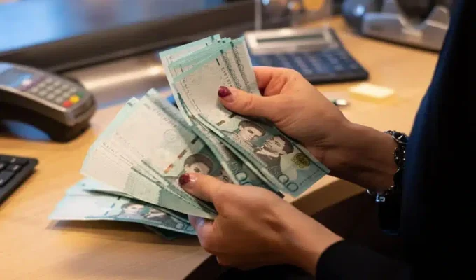 A Bank Teller Counting Dominican Pesos